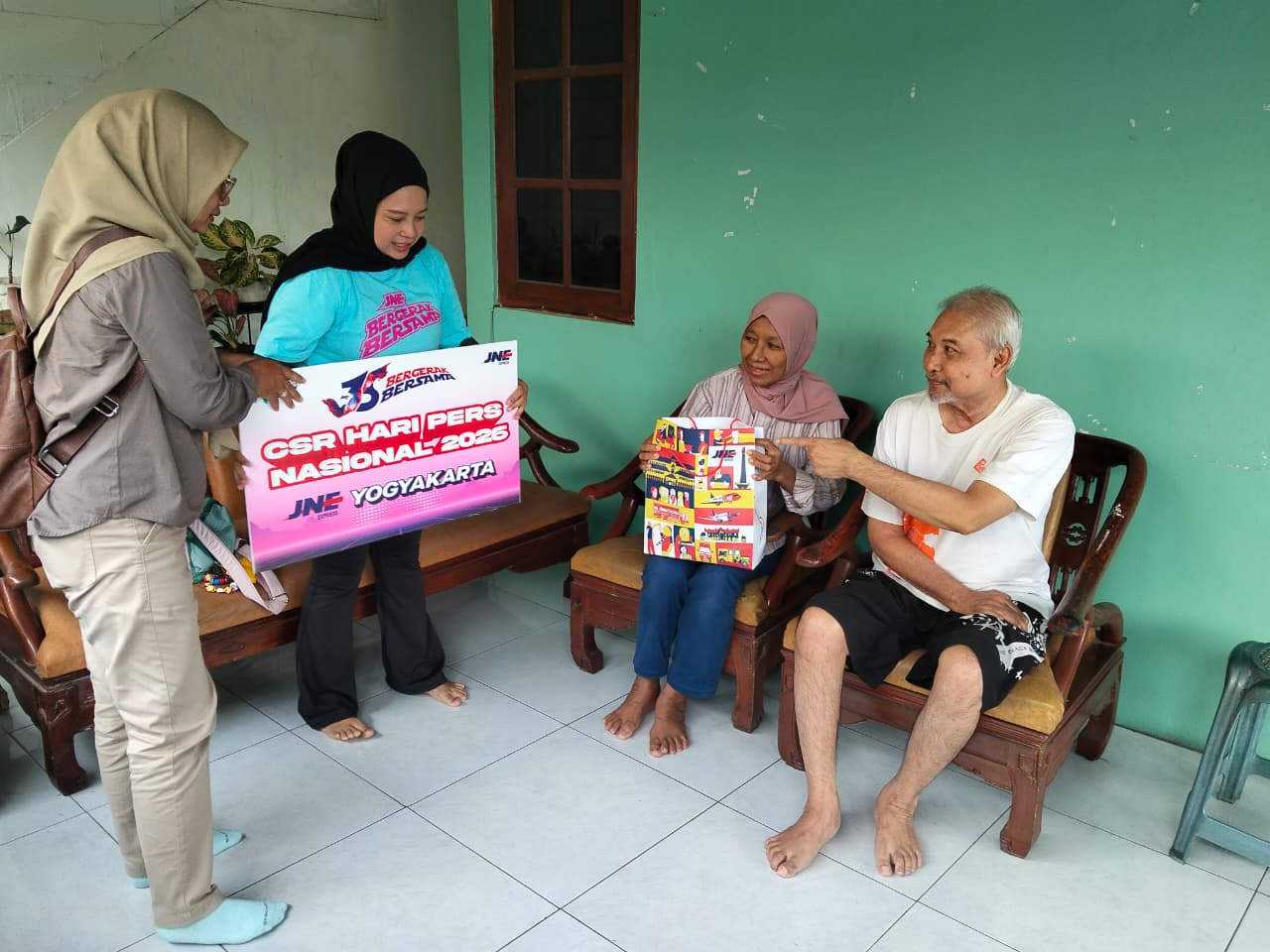 (baju putih) Mantan wartawan Wawasan, Anggoro Rulianto, menerima tali asih dalam peringatan HPN dari JNE di rumahnya, Sidokarto, Godean, Sleman, Selasa (10/2/2026).