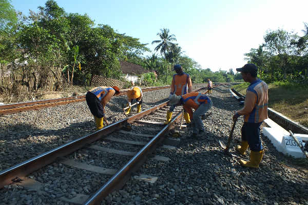 Sejumlah petugas membenahi dan merawat rel kereta api di salah satu titik rel di Dusun Bantar, Desa Banguncipto, Kecamatan Sentolo, beberapa waktu lalu. Titik tersebut merupakan salah satu perlintasan sebidang tak berpalang pintu dan tak berpenjaga di Kulonprogo. Harian Jogja/Uli Febriarni