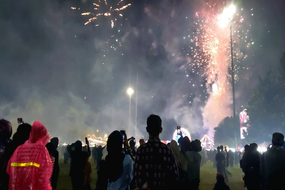 Gerimis Tak Surutkan Warga Menunggu Malam Pergantian Tahun Baru 2025 di Lapangan Denggung